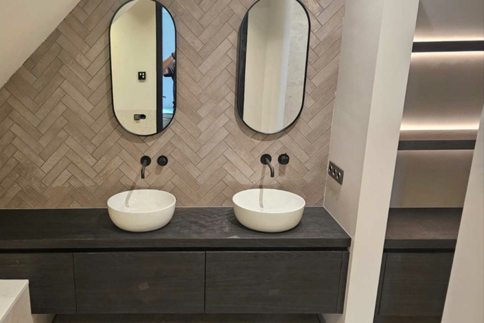 wastafelmeubel met witte kom en zwarte kraan